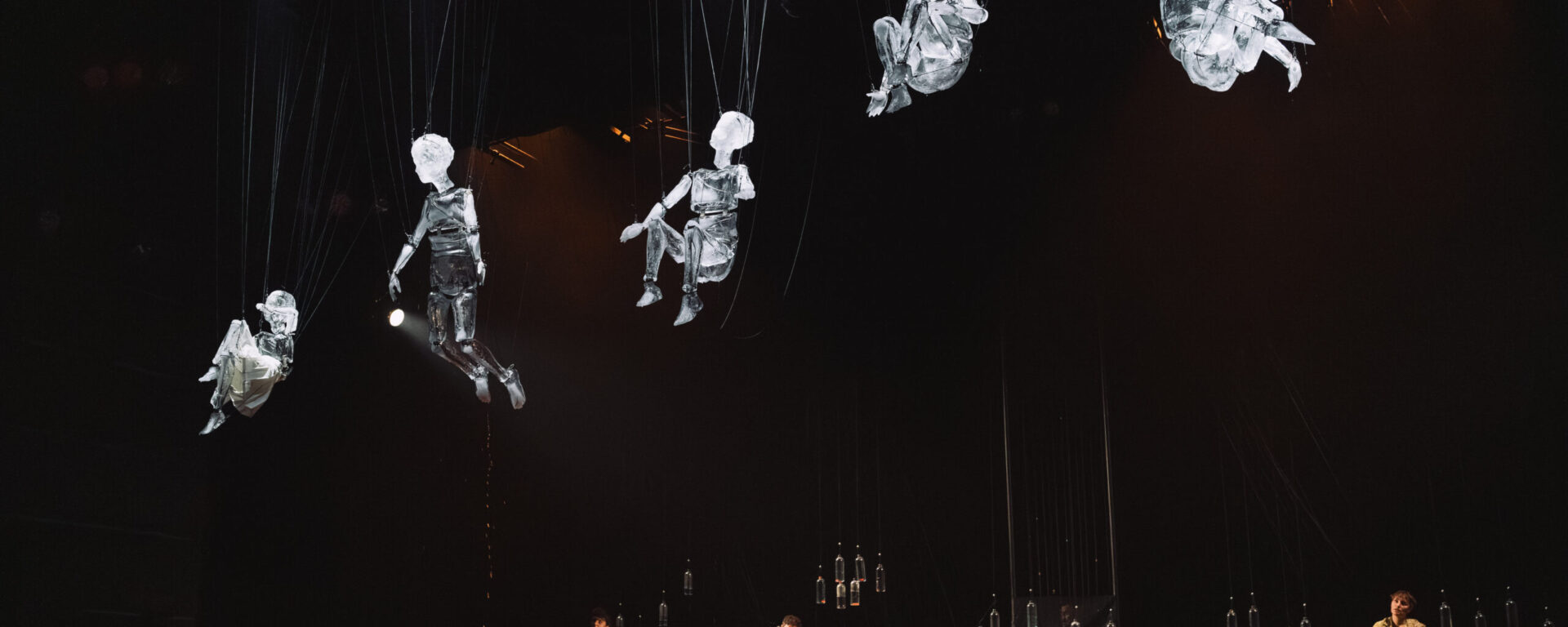 Cinq marionnettes de glace, représentant des enfants, suspendues à des fils, dans le spectacle Les Vagues, d’Élise Vigneron.