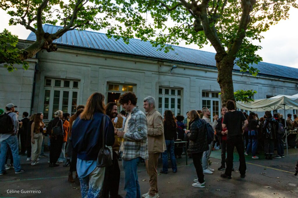 Des personnes discutent dans une cour d'école à côté des 3T - Théâtre du troisième type, lors de l'inauguration du lieu à Saint-Denis le 22 mai 2024.