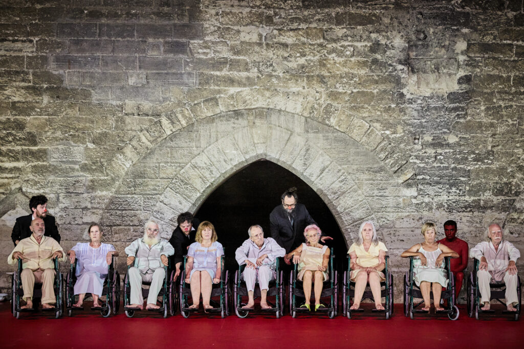 Des vieillards alignés dans des fauteuils roulants, dans le spectacle DÄMON d'Angelica Liddell au Festival d'Avignon.